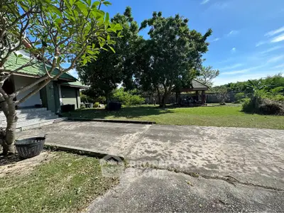 Spacious outdoor garden area with lush greenery and a charming gazebo, perfect for relaxation and outdoor activities.