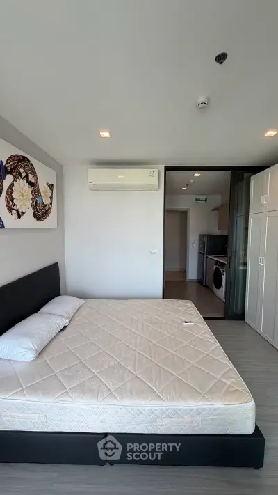 Spacious bedroom with modern decor and built-in storage in a stylish apartment.