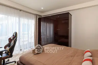 Cozy bedroom with large window and stylish furniture, perfect for relaxation.