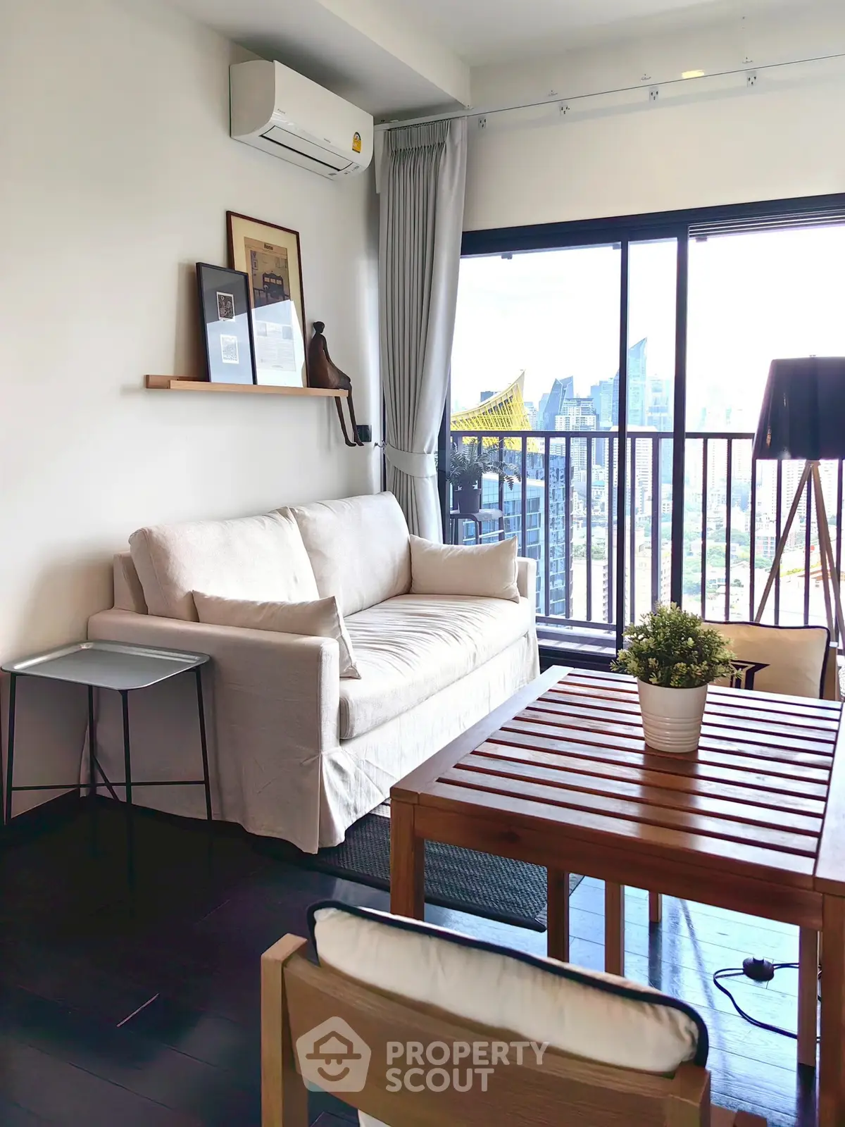 Chic living room with modern decor and stunning city view from balcony.
