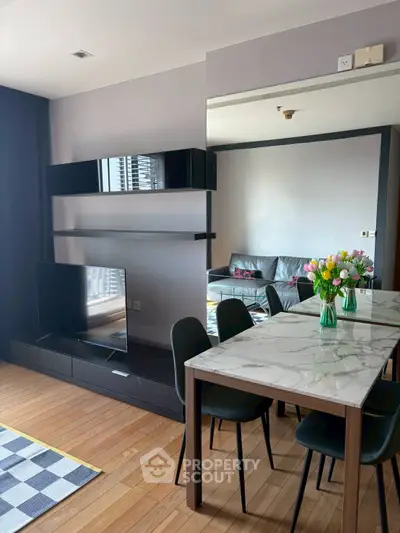 Modern living room with sleek TV setup and elegant dining area