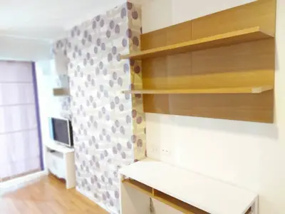 Modern living room with stylish wallpaper and wooden shelves, perfect for cozy urban living.