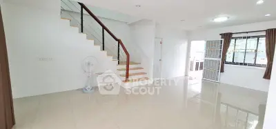 Spacious open-plan living area with staircase and large windows in modern home