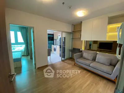 Modern apartment interior with cozy living room and adjacent bedroom, featuring wooden flooring and stylish decor.