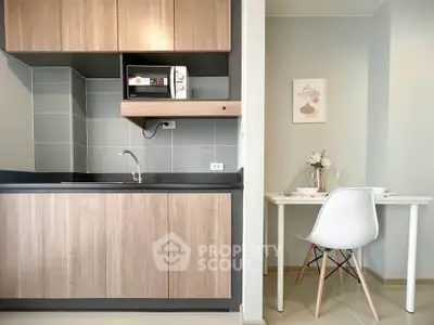 Modern kitchen with sleek cabinets and cozy dining area in stylish apartment.
