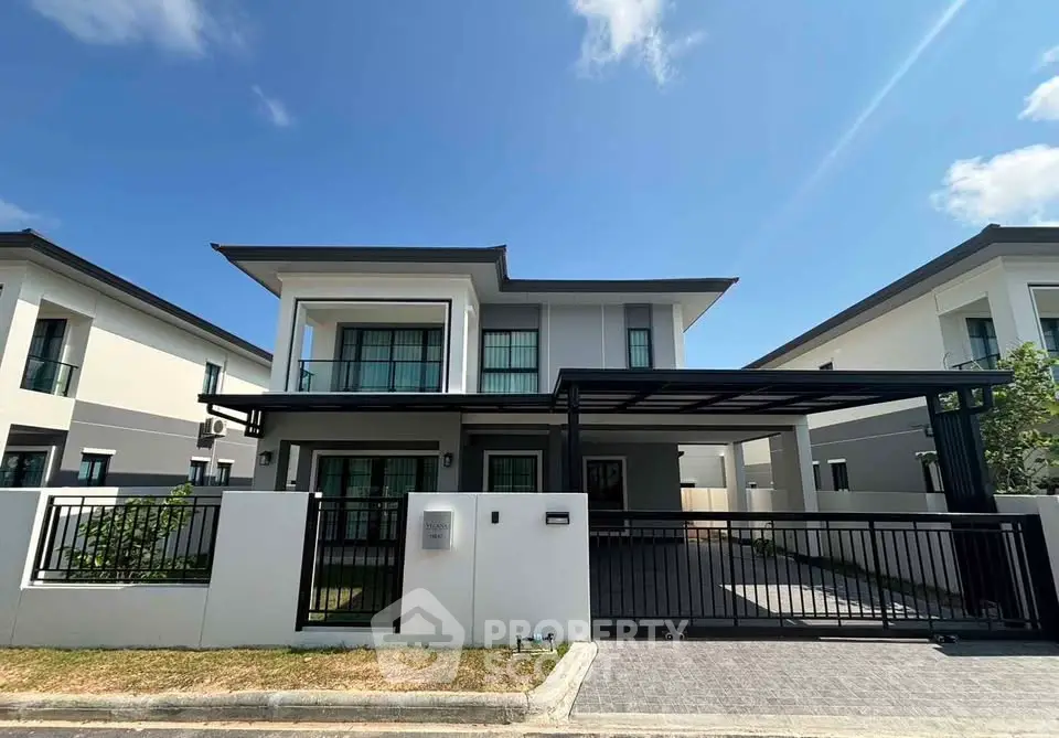 Modern two-story house with sleek design and spacious driveway, perfect for family living.