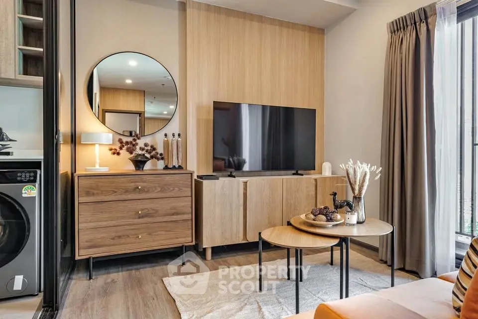 Modern living room with stylish decor, featuring a flat-screen TV, wooden furniture, and a cozy ambiance.