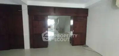 Spacious interior with wooden sliding doors and glossy tiled flooring, ideal for modern living.