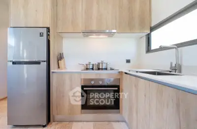 Modern kitchen with stainless steel appliances and sleek wooden cabinetry