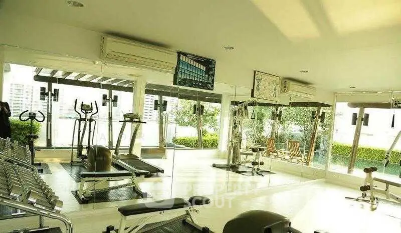 Spacious modern gym with city view and state-of-the-art equipment