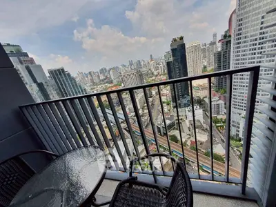 Stunning cityscape view from a high-rise balcony with modern furniture, perfect for urban living.