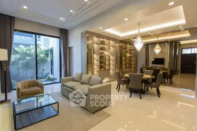 Luxurious open-plan living and dining area with elegant chandeliers and modern furnishings.
