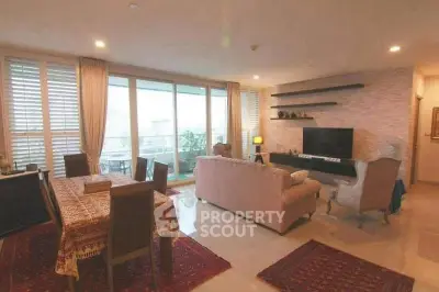 Spacious living room with elegant decor and large windows offering city views.