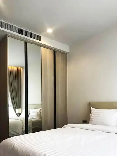 Modern bedroom with sleek wardrobe and cozy bedding in a stylish apartment.