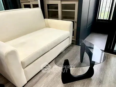 Modern living room with sleek glass coffee table and cream sofa