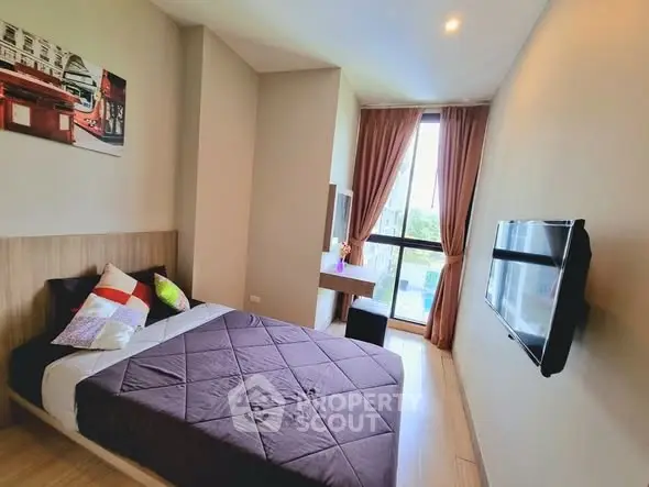 Modern bedroom with large window and wall-mounted TV in stylish apartment