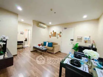 Modern living room with elegant decor and dining area, featuring wooden flooring and cozy seating.