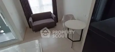 Cozy modern living room with natural light, featuring a stylish sofa and elegant round table.