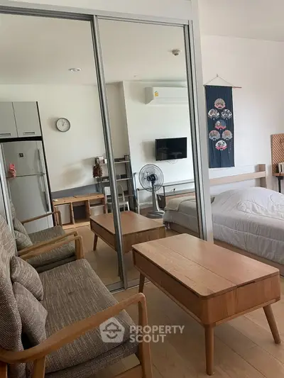 Modern studio apartment with stylish wooden furniture and mirrored closet doors.