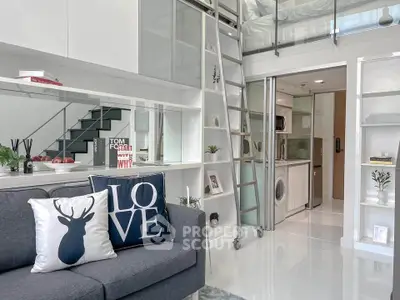Modern loft apartment with stylish living area and compact kitchen featuring a washing machine.