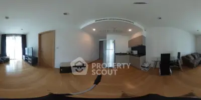 Spacious modern living room with open kitchen and sleek appliances in a contemporary apartment.