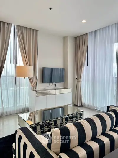 Luxurious modern living room with striped sofa and floor-to-ceiling windows