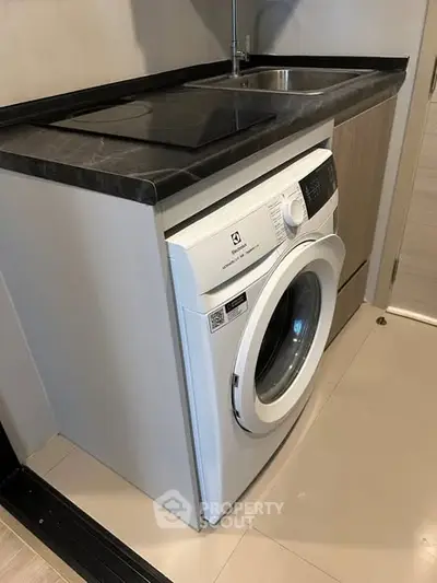 Compact kitchen corner with washing machine and sleek countertop