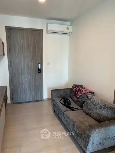 Modern living room with sleek sofa and air conditioning, perfect for cozy urban living.