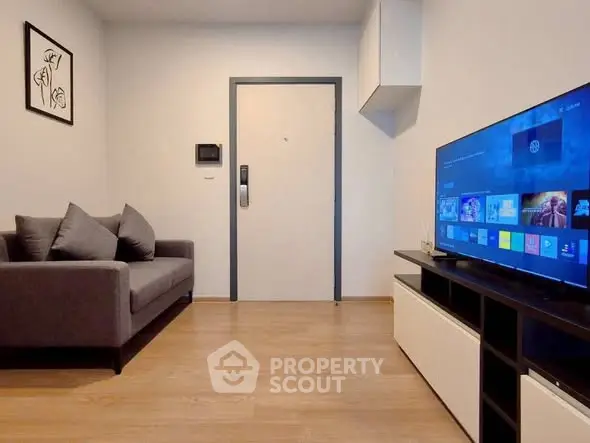 Modern living room with sleek sofa and large flat-screen TV, perfect for relaxation and entertainment.