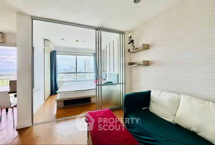 Modern apartment with sliding glass doors, cozy living area, and stunning city view from the bedroom.
