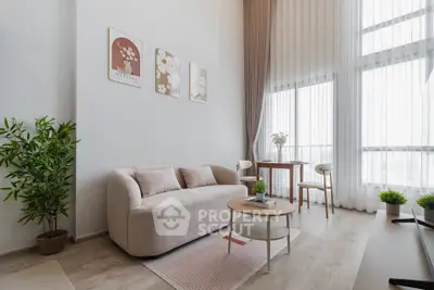 Modern living room with elegant decor and large windows offering natural light.