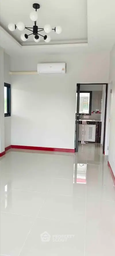 Spacious empty room with modern lighting and air conditioning, ideal for customization.