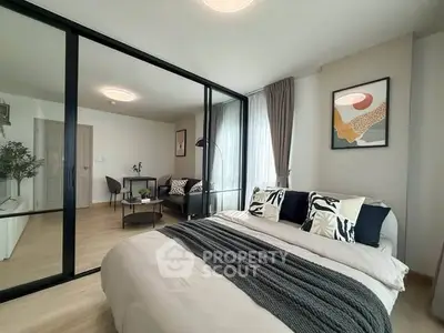 Modern bedroom with glass partition and stylish decor in open-plan apartment.
