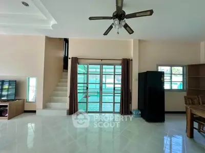 Spacious living room with modern ceiling fan and large windows