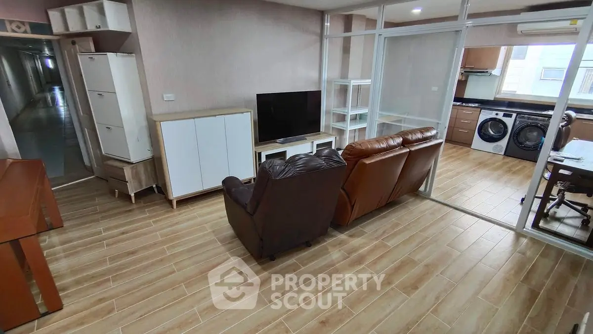 Spacious living room with modern furniture and in-unit laundry setup