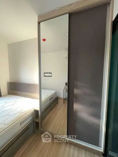 Modern bedroom with large mirror wardrobe and natural light