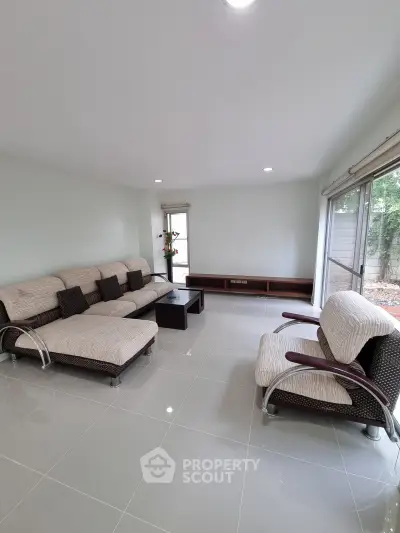 Spacious modern living room with sleek tile flooring and comfortable seating, perfect for relaxation.