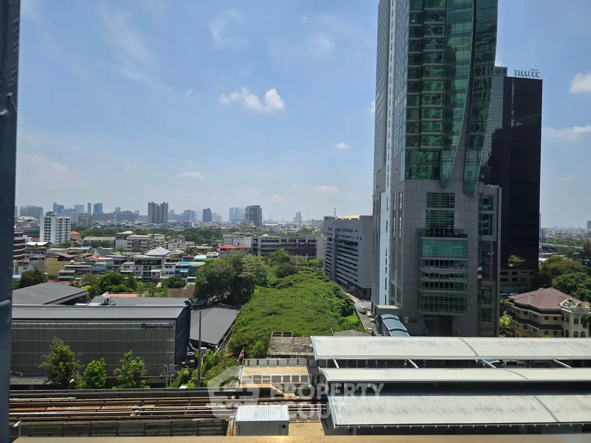 Stunning cityscape view from high-rise building showcasing urban skyline and lush greenery.
