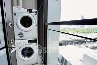 Modern balcony with stacked washer and dryer overlooking cityscape