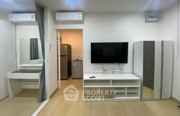 Modern living room with sleek furniture and wall-mounted TV in a stylish apartment.