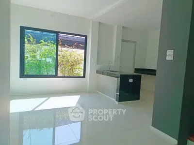Bright modern kitchen with large window and sleek countertops in a minimalist design.