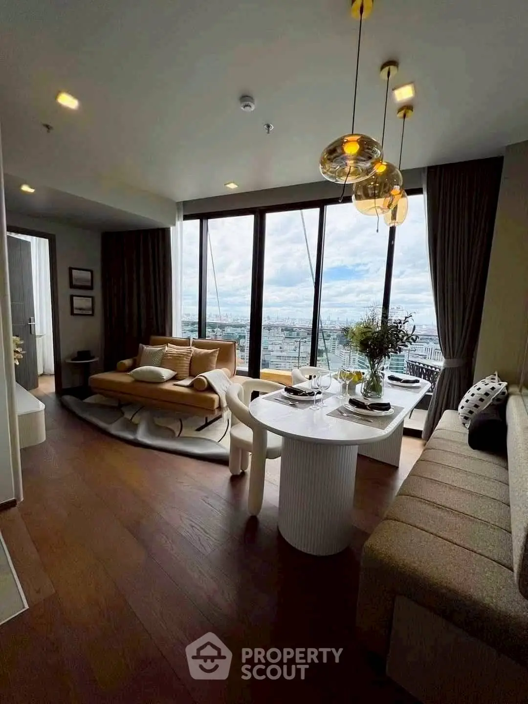 Luxurious living room with panoramic city view, modern decor, and elegant lighting.