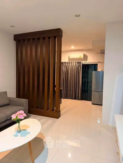 Modern living room with sleek design, featuring a cozy sofa, stylish coffee table, and elegant partition.