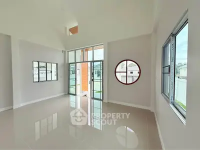 Spacious modern living room with large windows and unique circular window design.