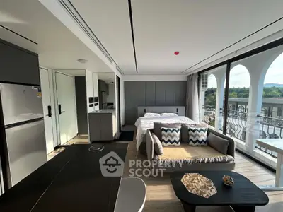 Modern studio apartment with open layout, featuring a cozy living area, bed, and kitchen with scenic balcony view.