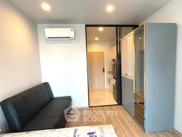 Modern living room with sleek sofa, air conditioning, and stylish wardrobe in a cozy apartment.