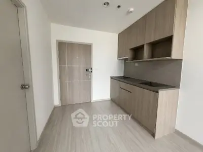 Modern minimalist kitchen with sleek wooden cabinetry and neutral tones.