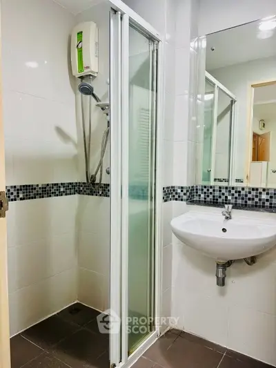 Modern bathroom with sleek shower and stylish sink in contemporary apartment.