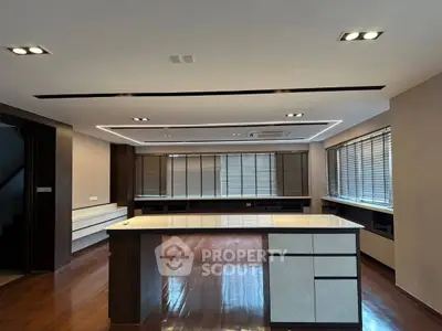 Spacious modern living room with sleek wooden flooring and large windows for natural light.