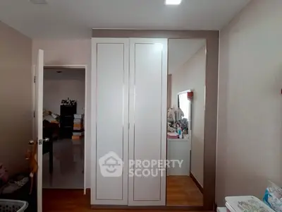 Modern bedroom with sleek wardrobe and wooden flooring